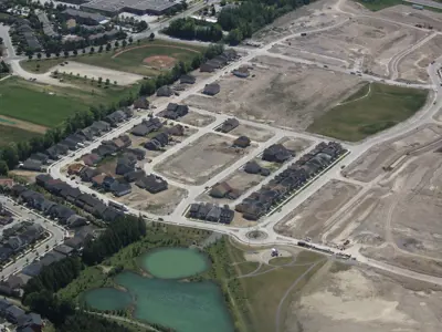 Aerial of new development area with construction, stormwater pond