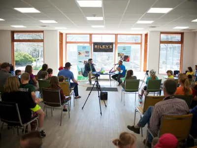guest speaker being interviewed in front of a group of people sitting in chairs