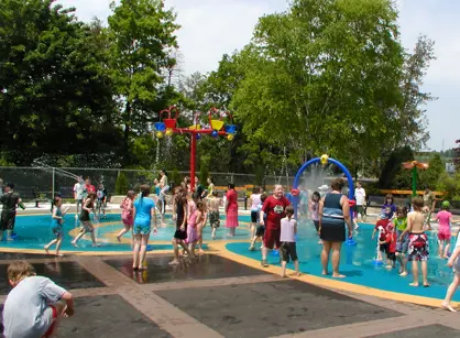 a splash pad water sprinklers and children playing