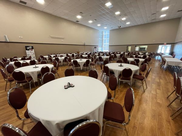 Banquet Hall at Healthy Planet arena set up with round tables, white tablecloths and chairs around each table