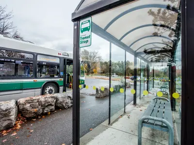 A sheltered bus stop with a bus waiting for passengers